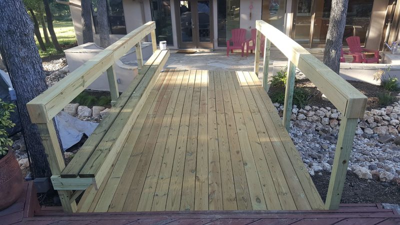 Footbridge with a bench rail over a dry creek